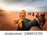 Happy tourist having fun enjoying group camel ride tour in the desert - Travel, life style, vacation activities and adventure concept