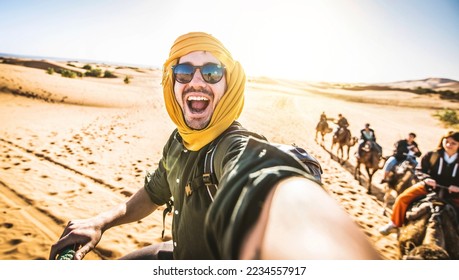 Happy tourist having fun enjoying group camel ride tour in the desert - Travel, vacation activities and adventure concept - Powered by Shutterstock