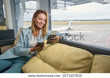 Happy tourist looking at boarding ticket in her hand