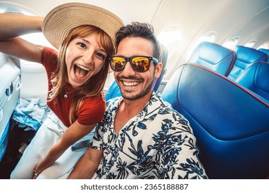 Happy tourist taking selfie inside airplane - Cheerful couple on summer vacation - Passengers boarding on plane - Holidays and transportation concept - Powered by Shutterstock