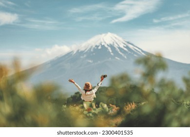 Happy tourist traveler woman enjoying with open arms on lake kawaguchiko with mount fuji in japan, spring and summer, Japan travel vacation - Shutterstock ID 2300401535