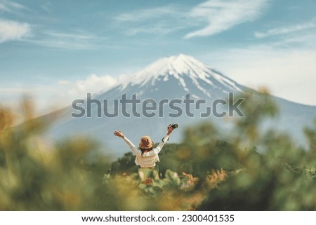 Happy tourist traveler woman enjoying with open arms on lake kawaguchiko with mount fuji in japan, spring and summer, Japan travel vacation