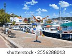 A happy tourist woman in the old port of Skiathos island, Greece, during summer time