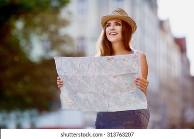 Happy Tourist Woman On Vacation With Map Visiting City