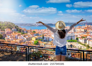 A happy tourist woman overlooks the colorful old town Alfama of Lisbon city, Portugal, and castle Sao Jorge on her sightseeing trip - Shutterstock ID 2157345181