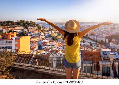 A happy tourist woman overlooks the colorful old town Alfama of Lisbon city, Portugal, and castle Sao Jorge during golden sunset time - Shutterstock ID 2172035107