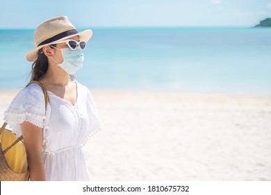 Happy tourist woman wearing surgical face mask  enjoy beautiful sea and white sand at tropical beach. protection Coronavirus disease (Covid-19) infection. New Normal, travel, vacation and holiday - Powered by Shutterstock