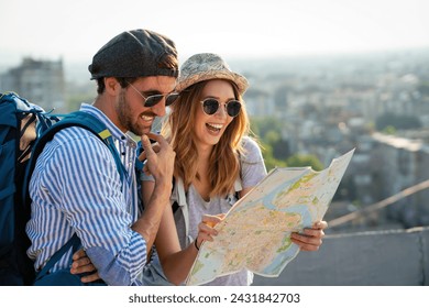 Happy tourists couple, friends sightseeing city with map together. Travel people concept. - Powered by Shutterstock