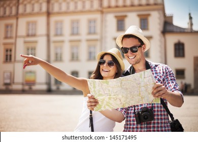 Happy tourists sightseeing city with map - Shutterstock ID 145171495
