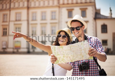 Happy tourists sightseeing city with map