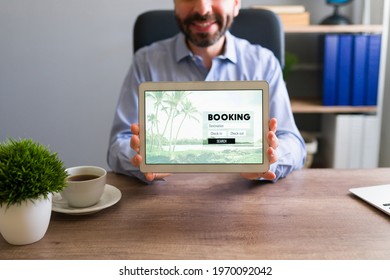 Happy Travel Agent Smiling While Holding A Tablet Screen With A Booking Trip. Sales Representative Showing Travel Information To A Customer At His Office