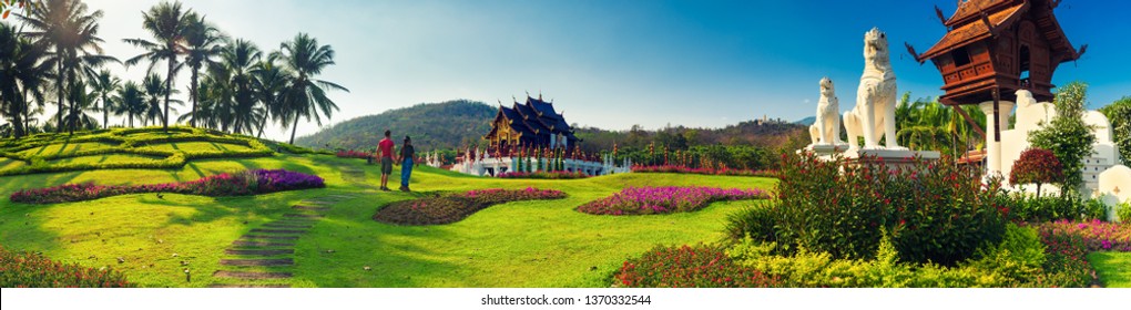 Happy travel couple explore scenery Thai architecture in the Lanna style in Thailand temple Royal Pavilion Ho Kum Luang / Chiang Mai, Thailand 