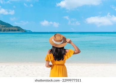 Happy traveler Asian woman on yellow dress relax on the tropical sandy beach. Summer, holiday concept. Copy space - Powered by Shutterstock