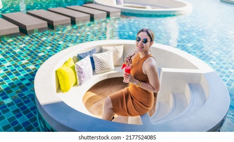 Happy Traveler Asian Woman Relaxing On Sunken Pool Lounge At Modern Luxury Resort Or Hotel, Attractive Asia Business People Joy Resting With Juice Glass, Travel Phuket Thailand Summer Vacation Holiday