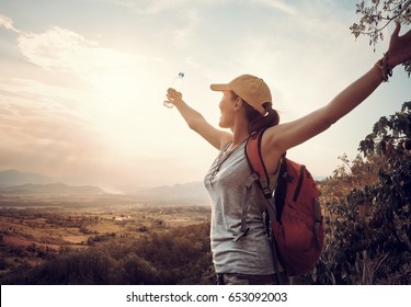 Happy Traveler With Backpack And Bottle Of Water Standing On Top Of Mountain And Enjoying Valley View With Raised Hands.
Mountains Landscape, Travel To Asia, Happiness Emotion, Summer Holiday Concept