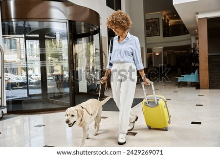 happy traveler with her Labrador in a pet-friendly hotel entrance, african american woman with dog