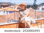 Happy traveler senior woman in vacation visiting La Laguna in Santa Cruz de Tenerife admiring cityscape from the hotel roof