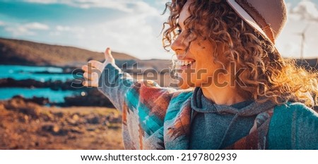 Happy traveler tourist enjoy landscape and nature beauty opening arms and smiling happy. Happiness and joyful female people lifestyle outstretching and admiring beautiful nature outdoors in leisure
