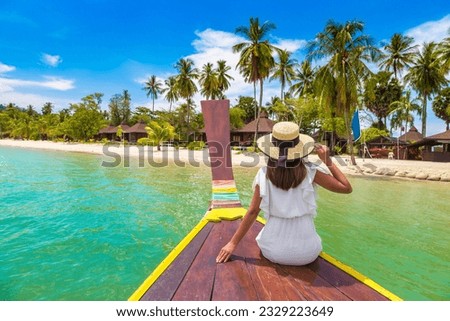 Happy traveler woman relaxing on boat near tropical island in Thailand