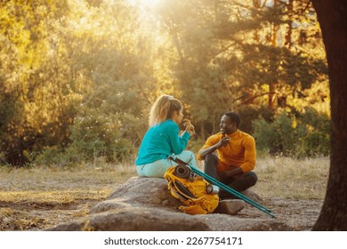 Happy traveler young biracial couple resting in nature at sunset in spring or summer season. - Powered by Shutterstock