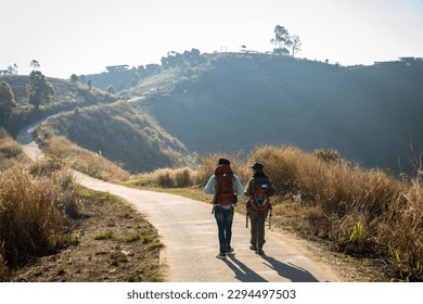 Happy Travelers Hiking with Backpacks on the Beautiful Rocky Trail at Warm Sunny. Hikers with backpacks walks in mountains. travel in the mountains with backpacks. Travel in the mountain with backpack - Powered by Shutterstock