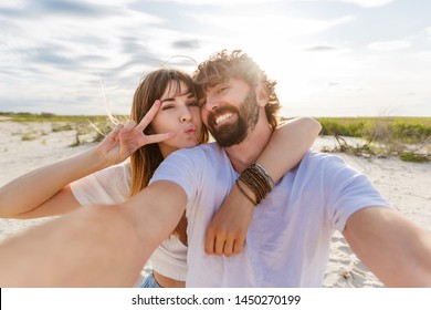 Happy traveling couple in love taking a selfie on phone at the beach on  summer day. Pretty girl and her handsome boyfriend with beard having fun, crazy emotional faces , laughing. - Powered by Shutterstock