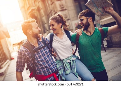 Happy traveling tourists sightseeing with map in hand - Powered by Shutterstock