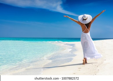Happy traveller woman in white dress enjoys her tropical beach vacation - Powered by Shutterstock