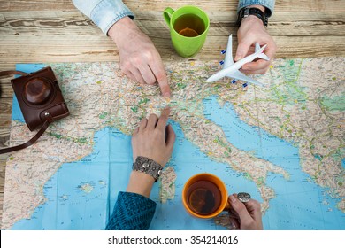 Happy travellers to Italy. Top view. Map and two people planning trip.