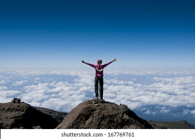 A happy trekker above the clouds on the route to the summit of Kilimanjaro