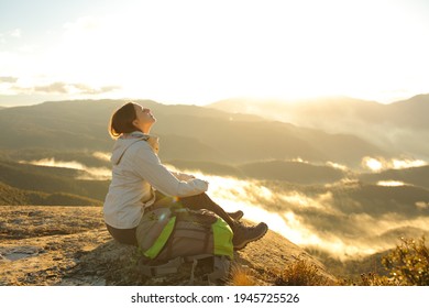 Happy trekker breathing fresh air in the top of a mountain at sunrise - Powered by Shutterstock