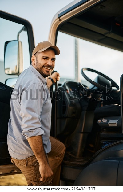 Happy\
truck driver entering in vehicle cabin and looking at camera.      \
                                                 \
