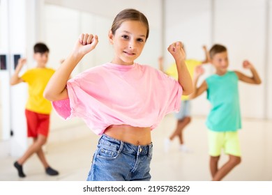 Happy Tween Girl Dancing With Children During Group Class In Modern Choreographic Studio.