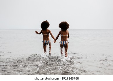 Happy Twin Sisters Running Inside Water During Summer Time.