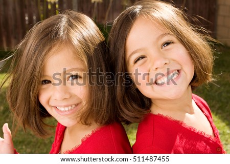 Happy twins sisters laughing