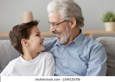 Happy Two 2 Generations Family Concept Smiling Senior Old Grandfather Embrace Cute Little Boy Grandson Laughing Hugging At Home, Grandparent And Grandchild Bonding Play Together Relaxing Sit On Sofa