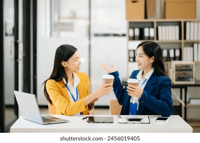 Happy two Asian business woman holding coffee cup in coworking office
 - Powered by Shutterstock