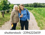 Happy two Explorers using mobile phone for navigation outdoors. Travel and active lifestyle concept. Road trip, transport, travel, technology and people banner