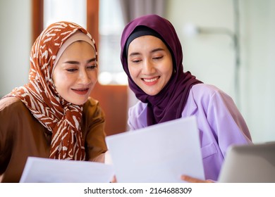 Happy Two Muslim Women At Home During Lesson, Studying Near Computer, Online Education. Culture, Traditions, Modern People.  Shopping Or Talking.