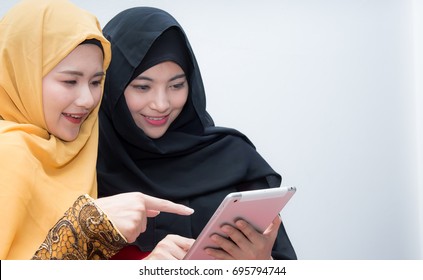 Happy two muslim women shopping online with pad, Asian Muslim women shopping online. Age 20-30 years.  - Powered by Shutterstock