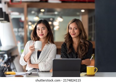 Happy Two Young Asian Business Woman Holding Coffee Cup In Office.