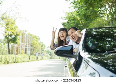 Happy Two Young Friends Driver Smiling While Sitting In A Car. Asian Man And Woman Chreeful Through Window. Young Couple Driving Car To Travel On Holiday Vacation Time.