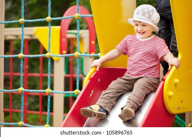 Happy two-year child on slide playground area