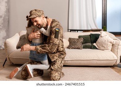 happy Ukrainian army soldier in camouflage uniform returned home and meets his daughter, the child runs to his military dad and hugs the veteran at home - Powered by Shutterstock