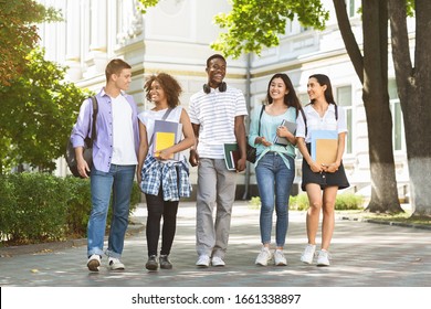 Happy University Students Walking Together On Campus, Chatting And Laughing Outdoors During Break, Copy Space