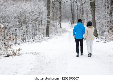 Happy Unrecognizable Older Couple Walking In A Winter Forest Exploring At Daytime