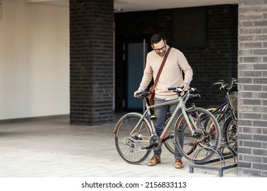 A happy urban man parking his bike outside. - Powered by Shutterstock