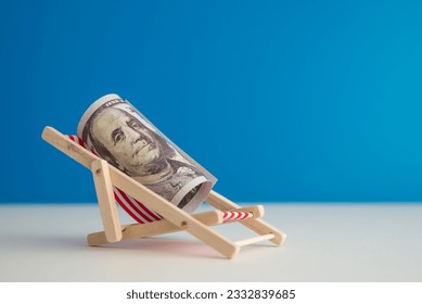 Happy US dollar bill banknote rest on wooden beach chair with blue background copy space in summer beach holiday. Financial freedom through passive income, success wealth from investment concept. - Shutterstock ID 2332839685