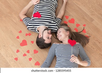 Happy valentines couple lying on the floor and looking at each other. Top view, toned. - Shutterstock ID 1285595455