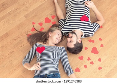 Happy valentines couple lying on the floor and looking at each other. Top view, toned. - Shutterstock ID 1291248388